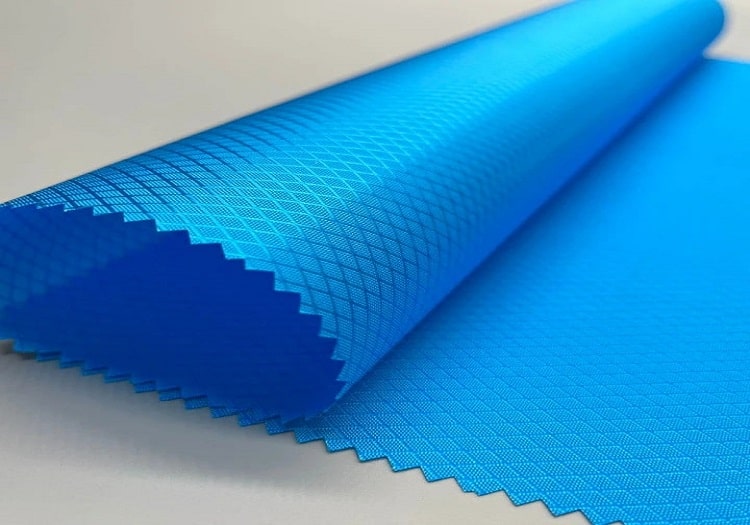 Poliéster Nikla Diamante (también conocido como Nicra), Poliéster Estrella, telas plastificadas con recubrimiento PVC, tipo Oxford, Cordura y Jacquard, impermeables, ideales para mochilas, bolsas ecológicas, carpetas, portafolios y detalles resistentes con acabado brillante o diamantado.