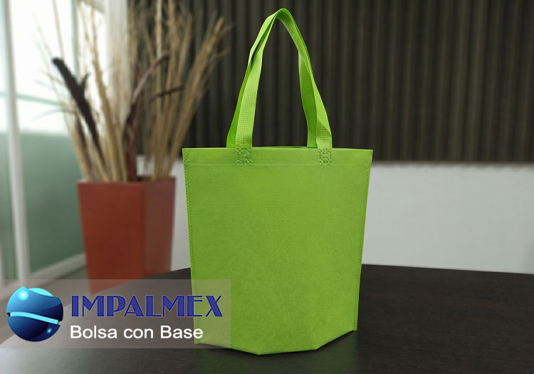 Bolsa ecológica de tela no tejida verde con base desplegable y asas reforzadas, fabricada en polipropileno non-woven.