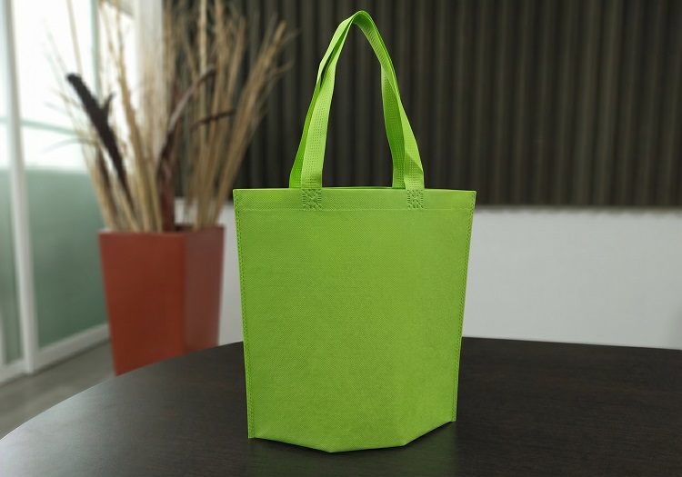 Fotografia de una bolsa ecologica impresa publicitaria abierta mostrando su base desplegable fabricada en pellon